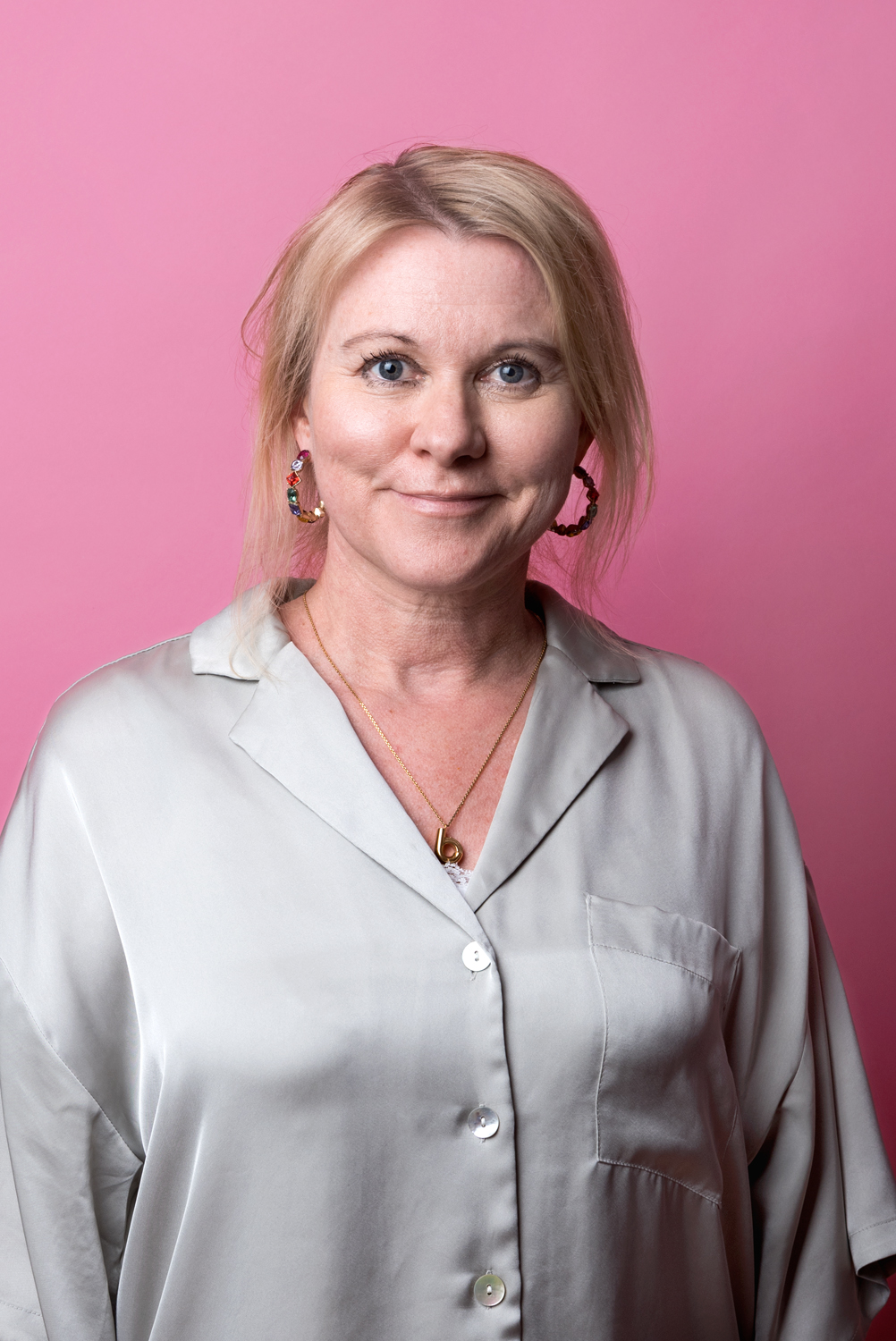 Porträttbild Beatrice Gustafsson. Beatrice har en vit, glansig blus på sig.