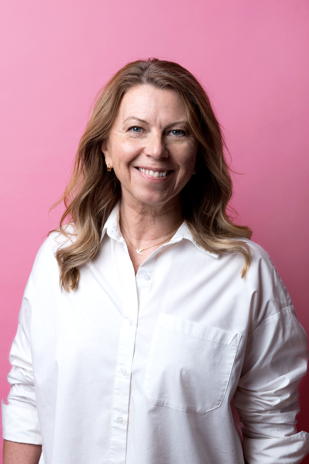 Porträttbild Veronica Kennett. Veronica har långt brunt hår, vit skjorta och ser glad ut.