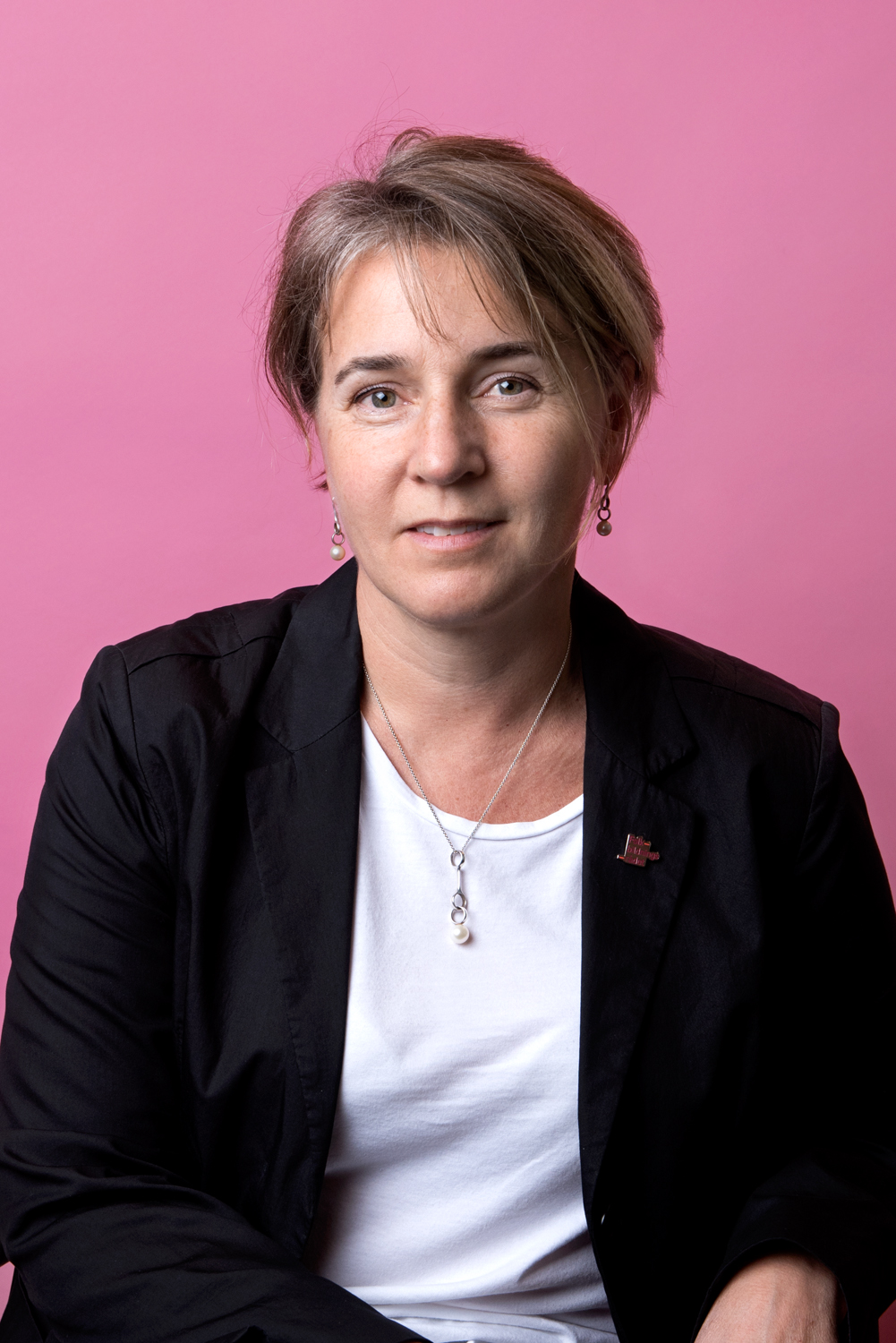Porträttbild Rebecka Svensén. Rebecka har en svart kavaj med en folkbildnignsrådet-pin på sig.
