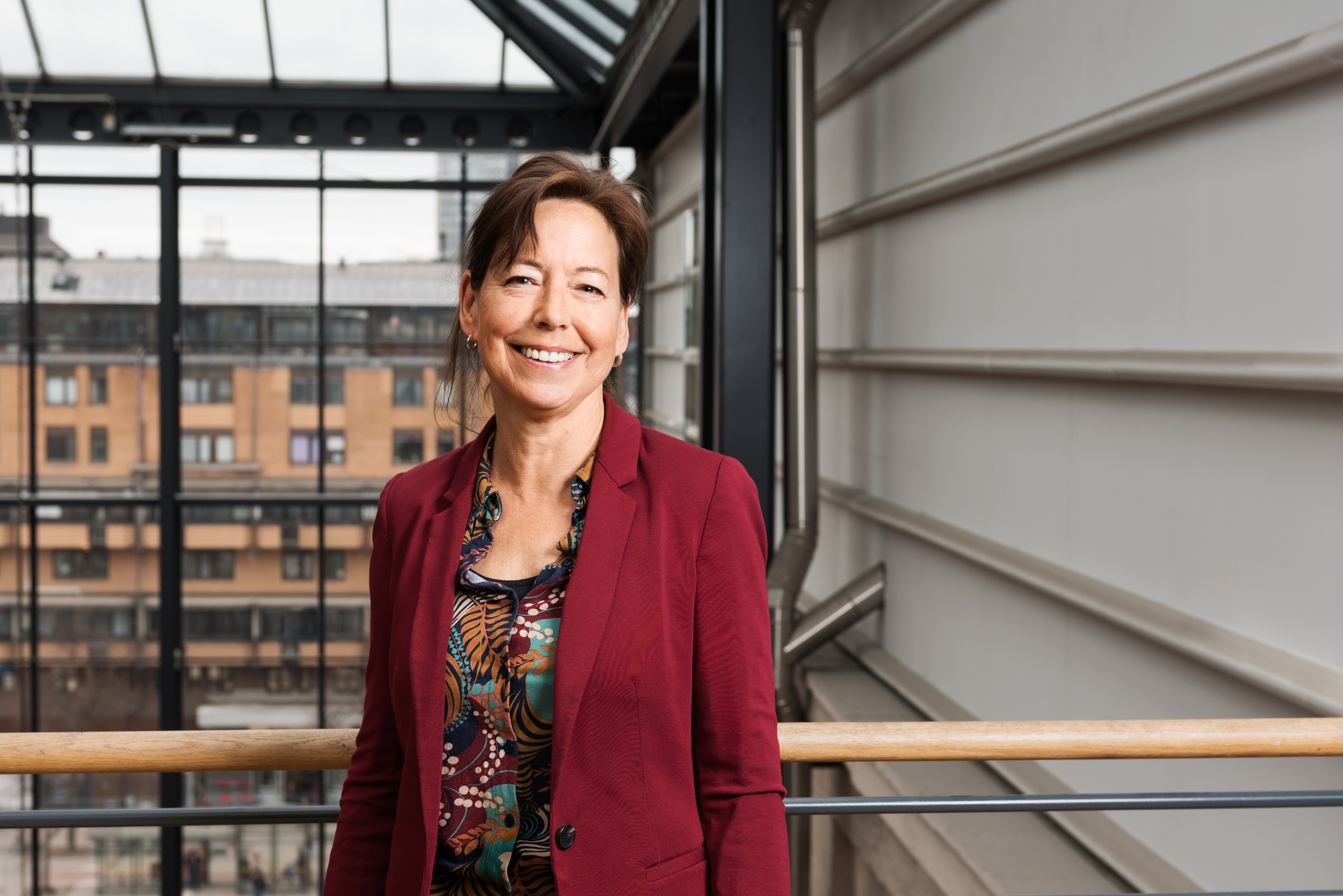 Porträttfoto av Anna-Karin Lindblom som har röd kavaj och ler mot kameran. Foto: Kerstin Westeson