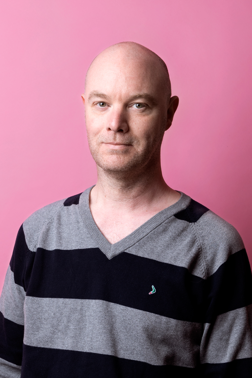 Porträttbild Robin Forsberg. Robin har en randig tröja i grått och svart på sig.