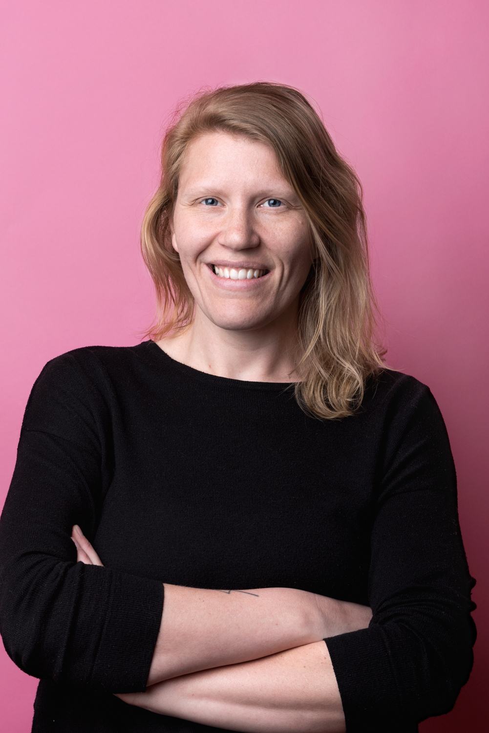 Porträttbild Elin Sundling. Elin har en svart tröja på sig och ler.