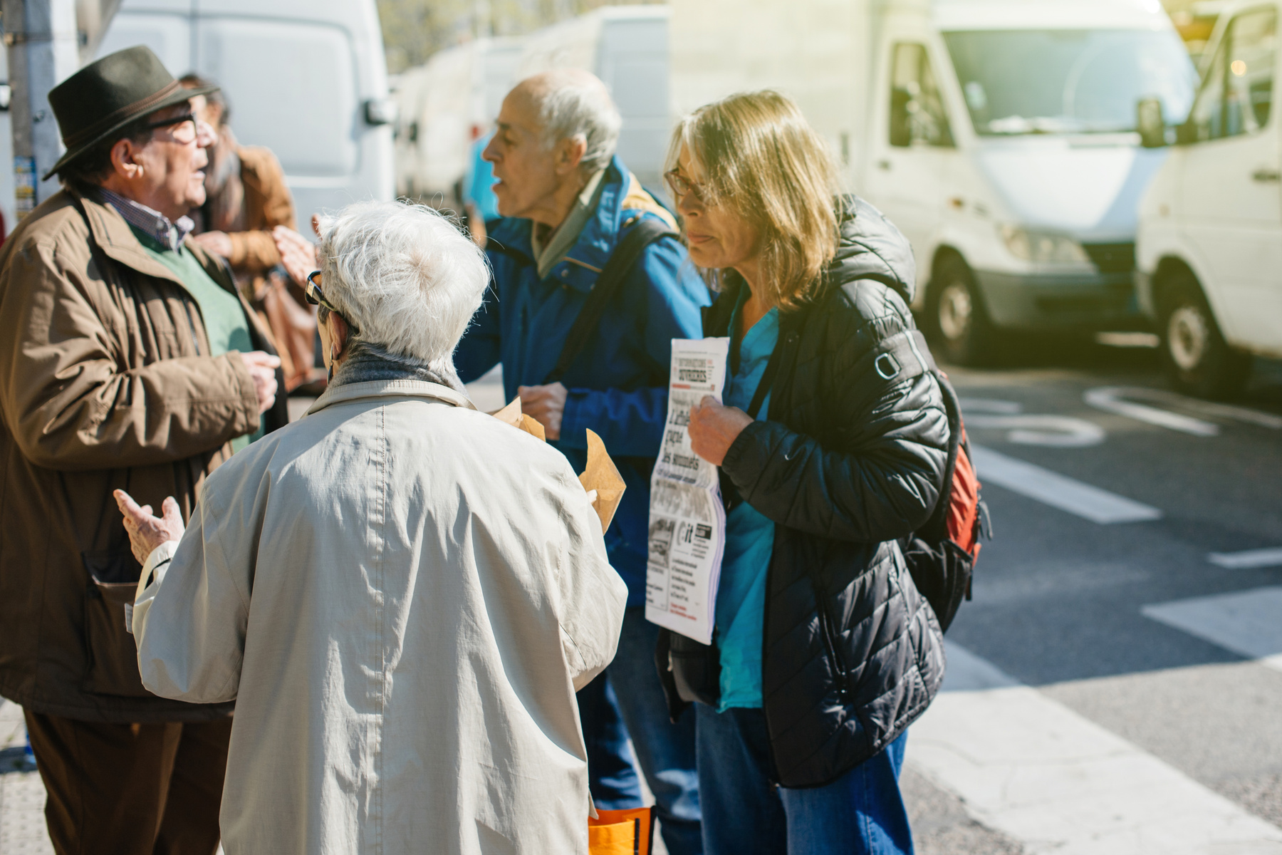Fyra äldre personer står och diskuterar politik på gatan.